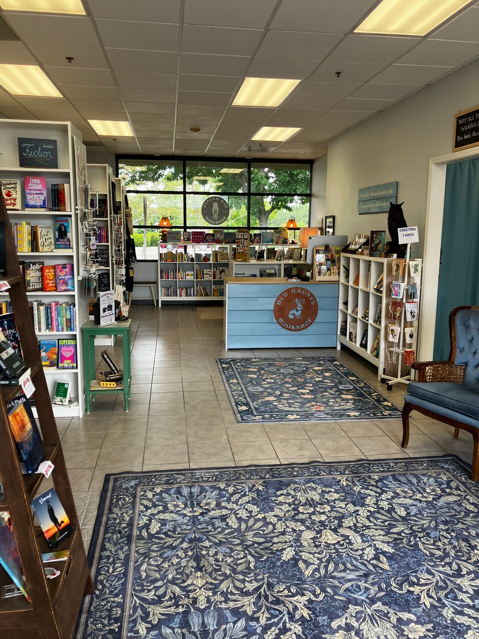 A look inside Old Haunts Bookshop with books on shelves, a checkout counter, and a cozy chair