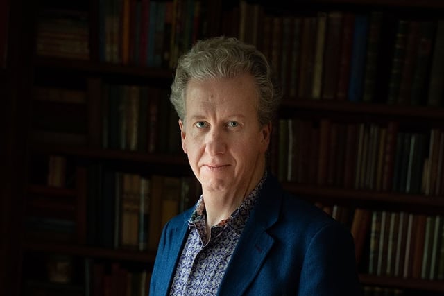 Author Charlie Lovett, a white man, wearing a dark blue blazer