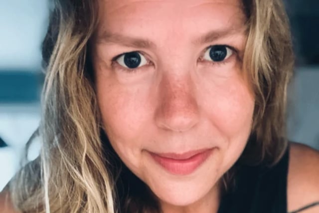 blonde woman in black tank top looking directly at the camera