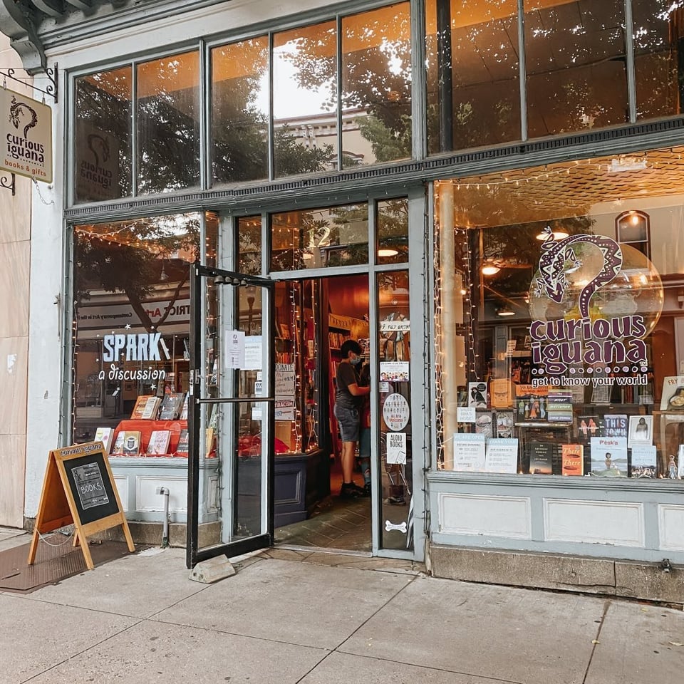 The store front is lit up with twinkle lights, and the door is open to welcome customers.
