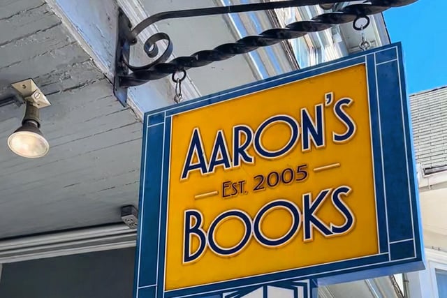 storefront with yellow sign and red, yellow, and orange balloons